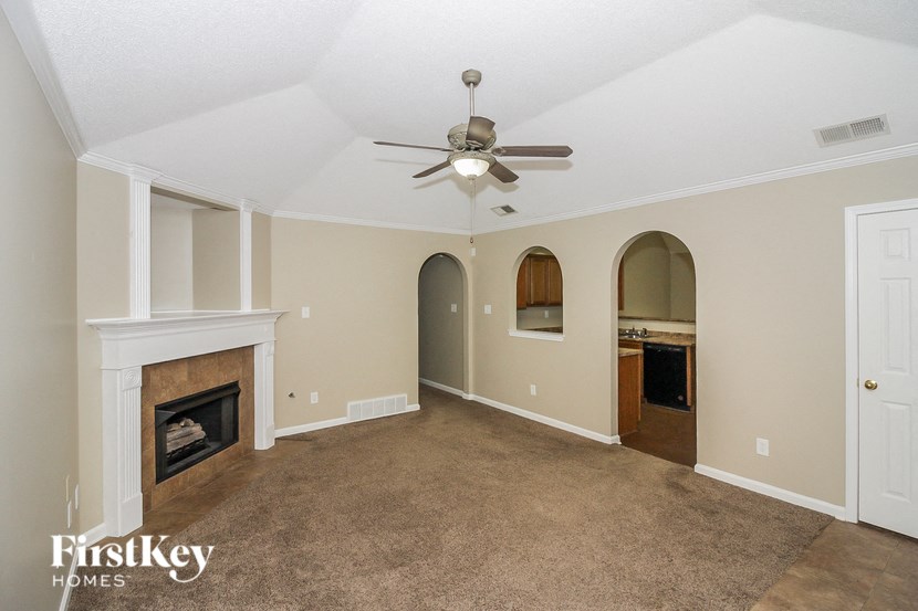 a living room with a fireplace and a ceiling fan