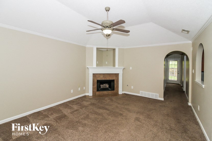 a living room with a fireplace and a ceiling fan