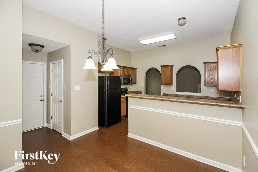 a kitchen with a counter top and a black refrigerator