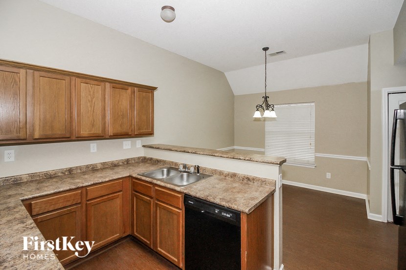an empty kitchen with wooden cabinets and a sink