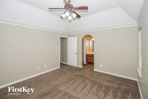 a living room with carpet and a ceiling fan