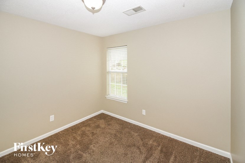 an empty room with carpet and a window