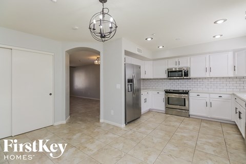 a large kitchen with white cabinets and stainless steel appliances