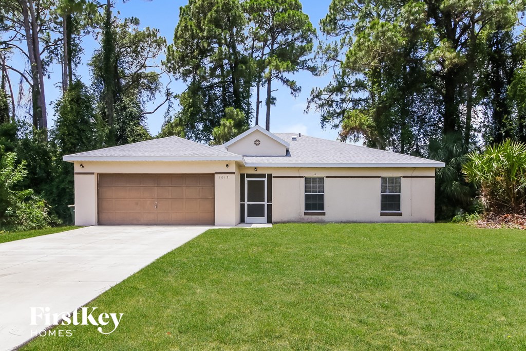 a white house with a lawn and a garage