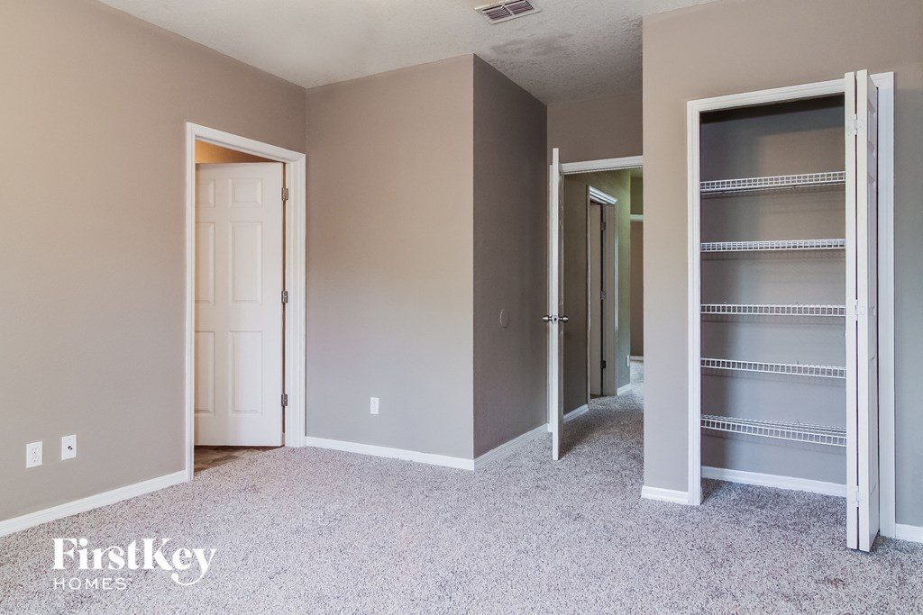 a bedroom with a closet and a hallway with open doors