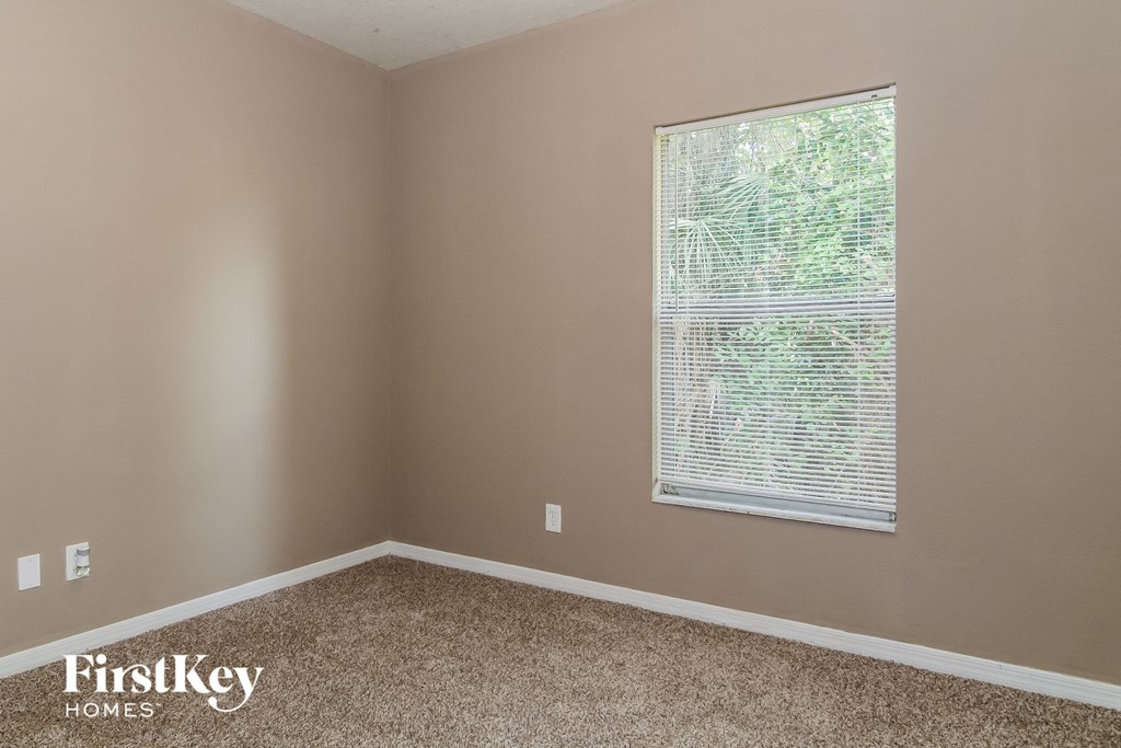 a room with a large window and a carpeted floor