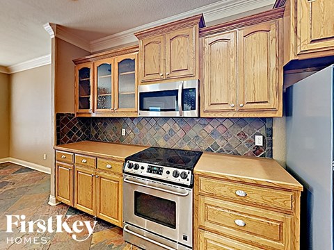A kitchen with wooden cabinets and a tile backsplash.
