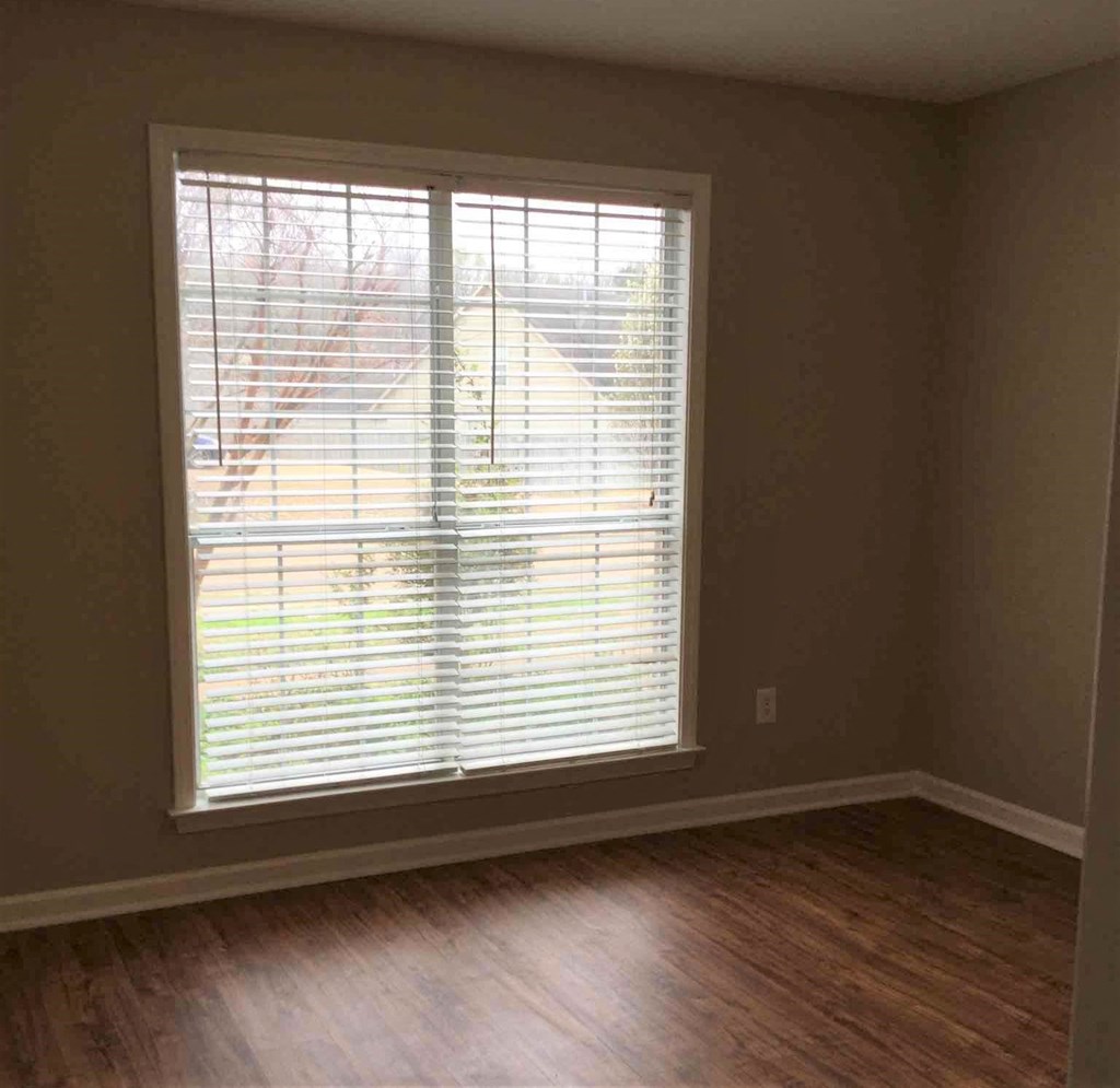 a living room with a large window and wood floors