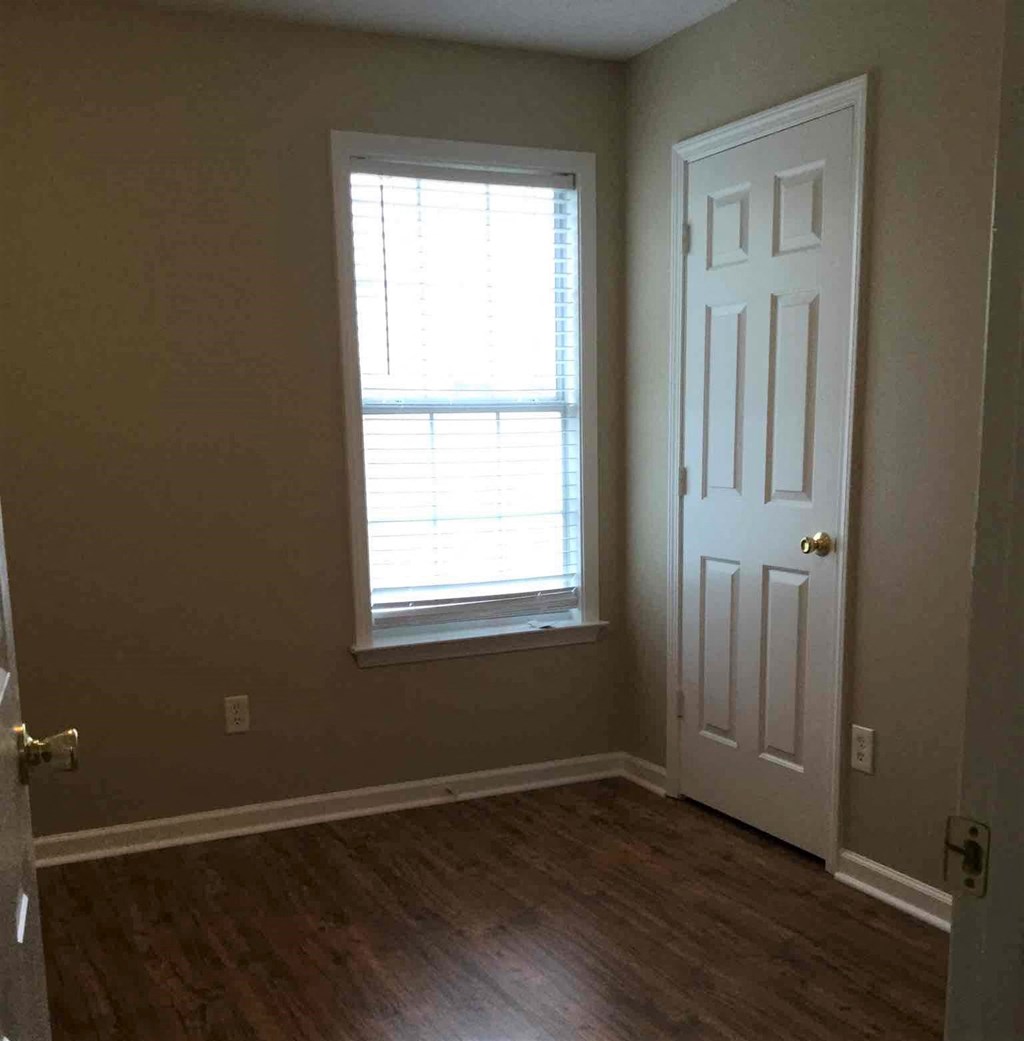 an empty room with a door and a window