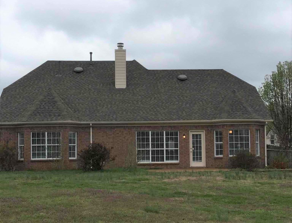 the front of a brick house on a grassy field