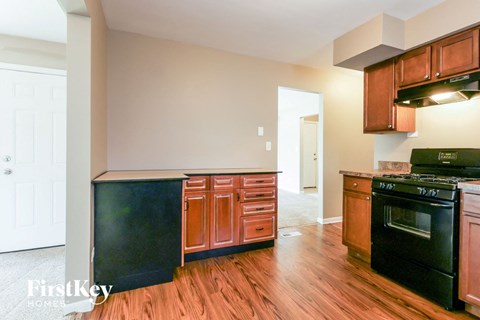 A kitchen with wooden floors and a black stove top oven.