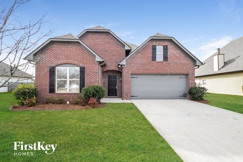 A brick house with a garage door and a driveway.
