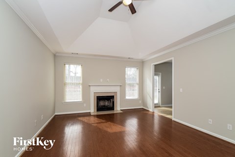 A spacious room with a fireplace and a ceiling fan.