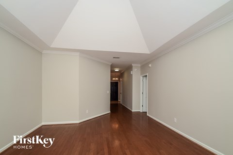 A long hallway with wood floors and white walls.
