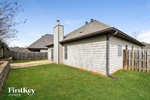 A house with a fence and a grassy yard.
