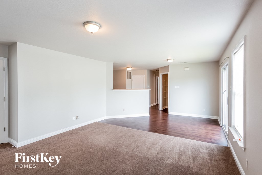 an empty living room with white walls and wood flooring