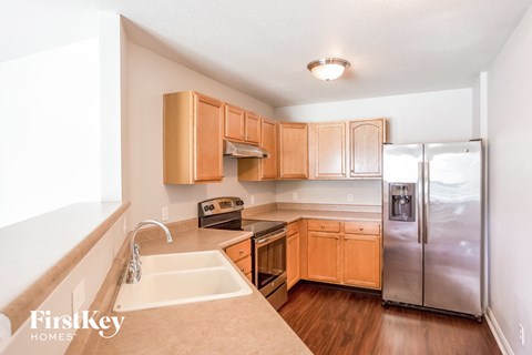 a kitchen with wooden cabinets and a stainless steel refrigerator