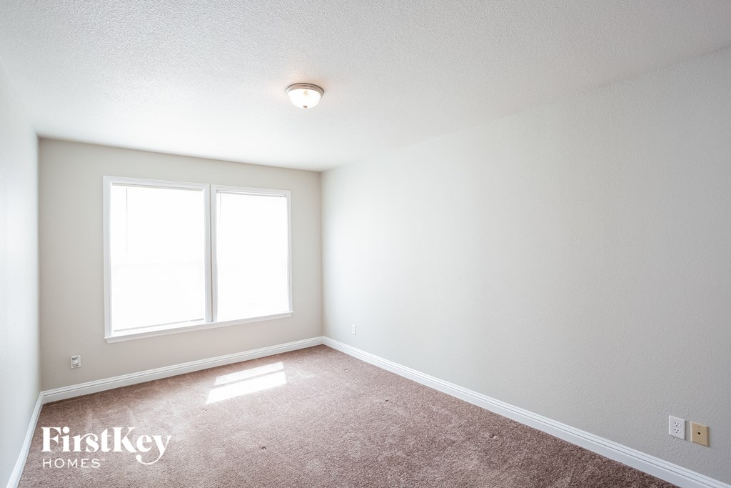 a empty room with a window and a carpet