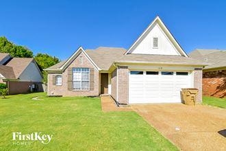 a brick house with a white garage door and a green lawn