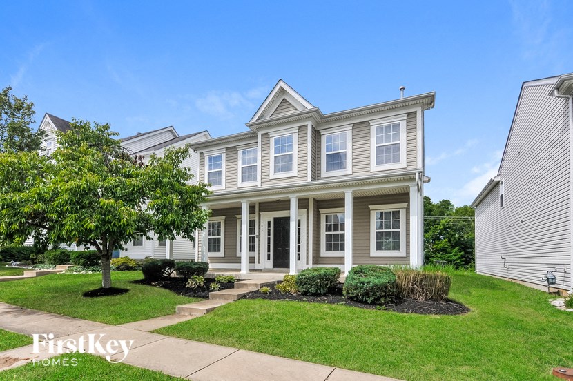 a white house with a lawn and trees in front of it