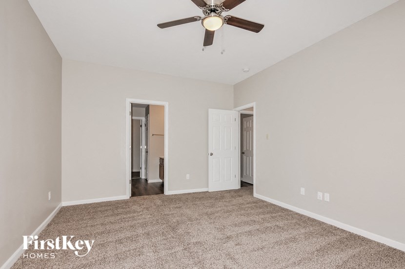 an empty living room with a ceiling fan