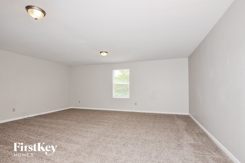 an empty room with carpet and a window