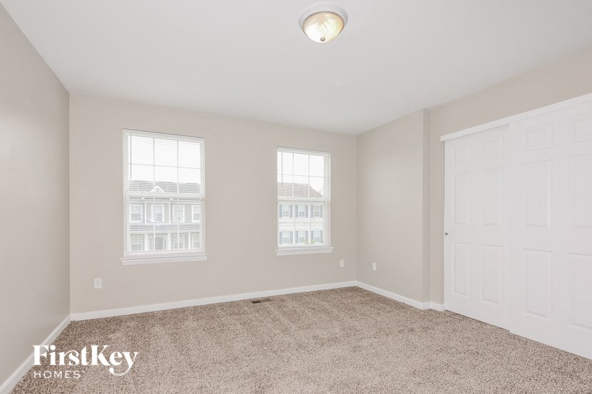 an empty room with two windows and a door