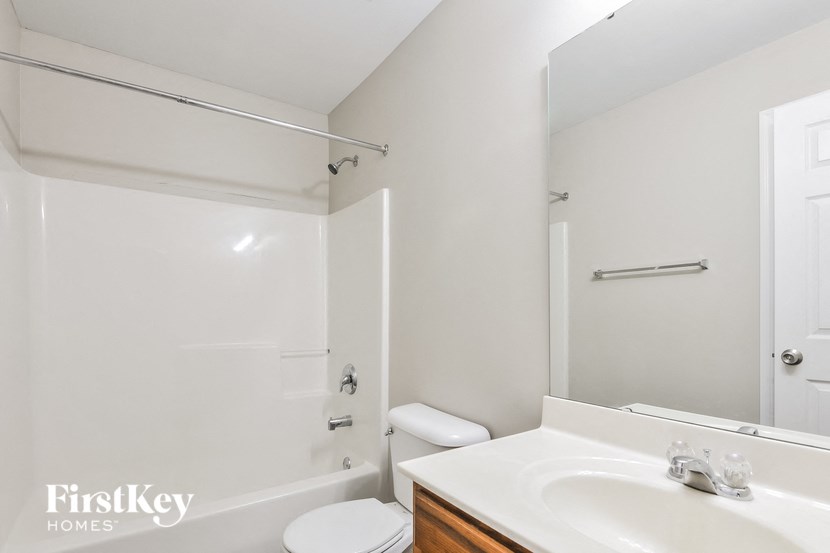 a white bathroom with a white sink and a toilet