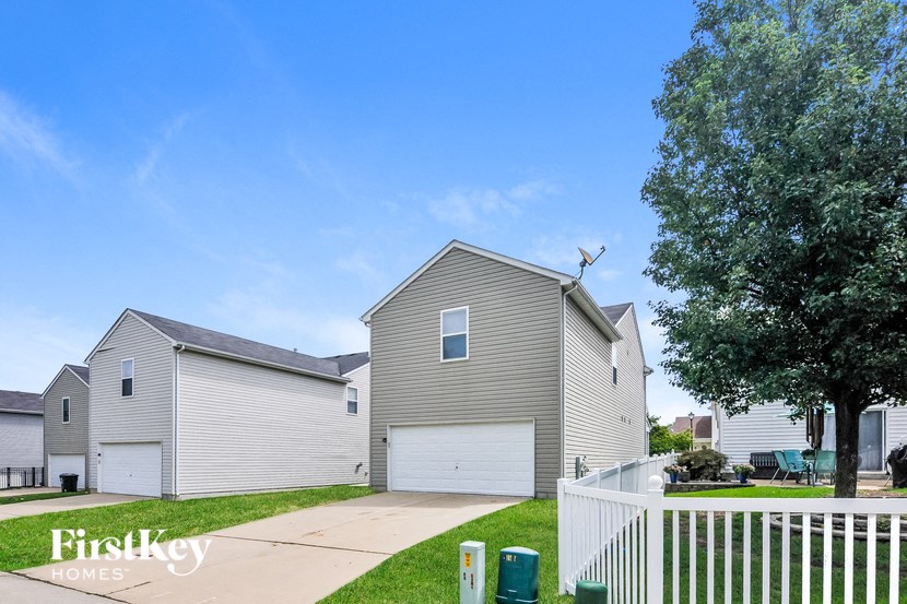 a gray house with a white fence and a yard