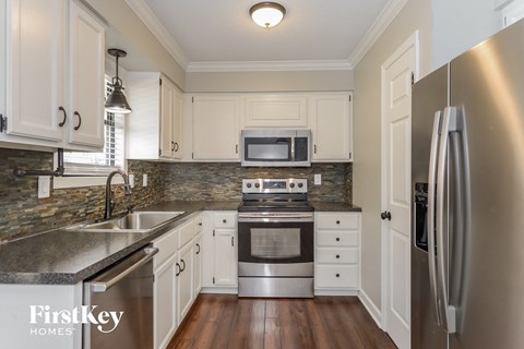 a kitchen with white cabinets and stainless steel appliances