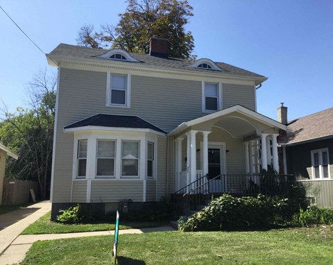 a renovated house with a front yard and a sidewalk