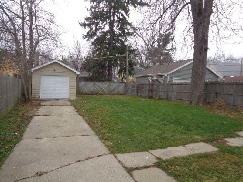 a sidewalk in front of a fence and a house