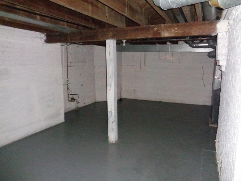 a basement with a concrete floor and a pole