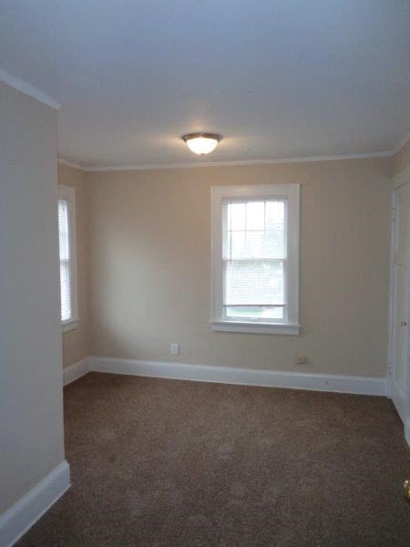 an empty room with a window and a carpet