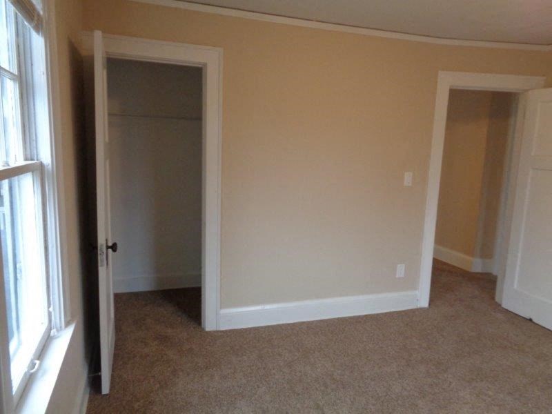 an empty living room with a door to a closet