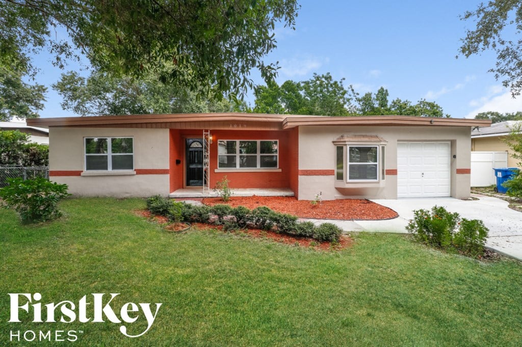 A house with a red front door and a white garage door.