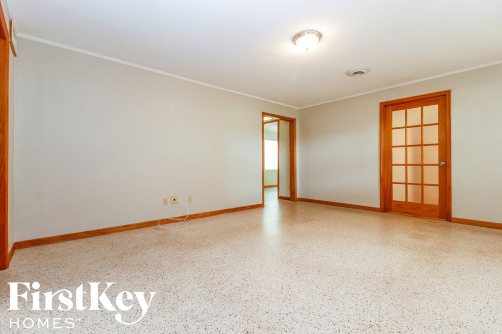 A spacious room with a door on the right and a window on the left.