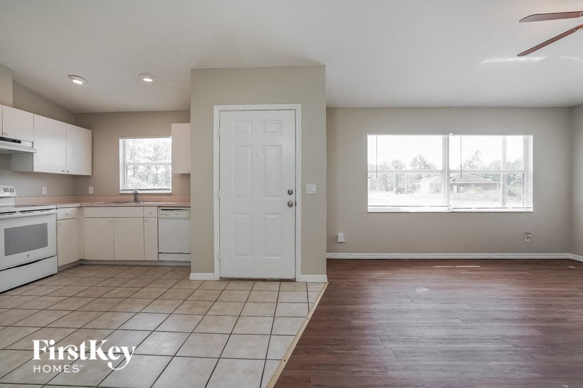 A kitchen with a white door and a window.