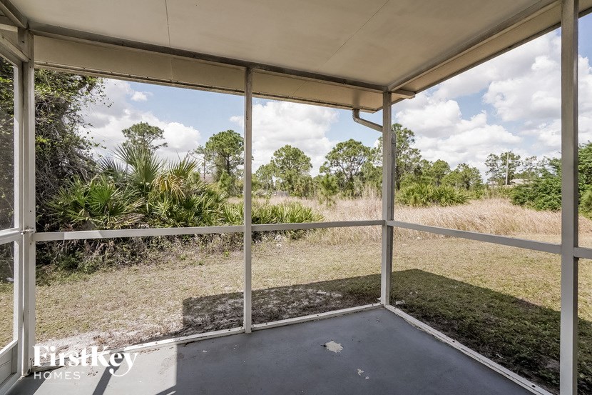 A porch with a white roof and a view of the trees.