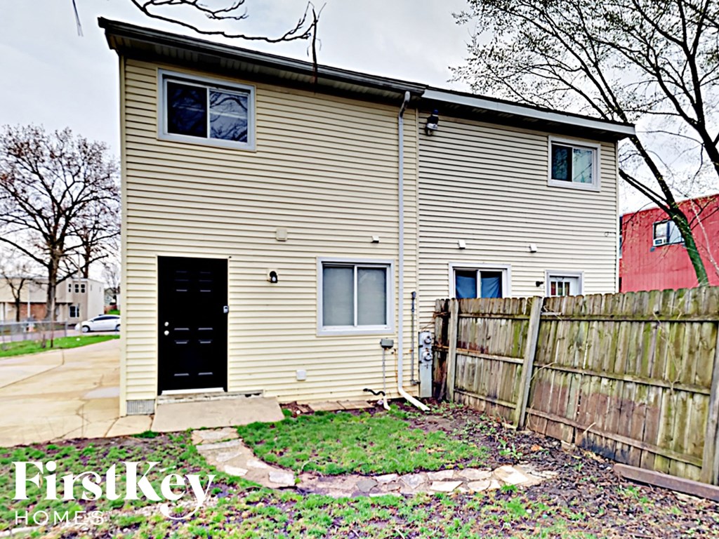 the back of a house with a wooden fence