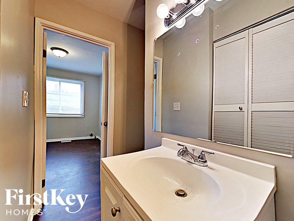 a bathroom with a sink and a mirror and a closet
