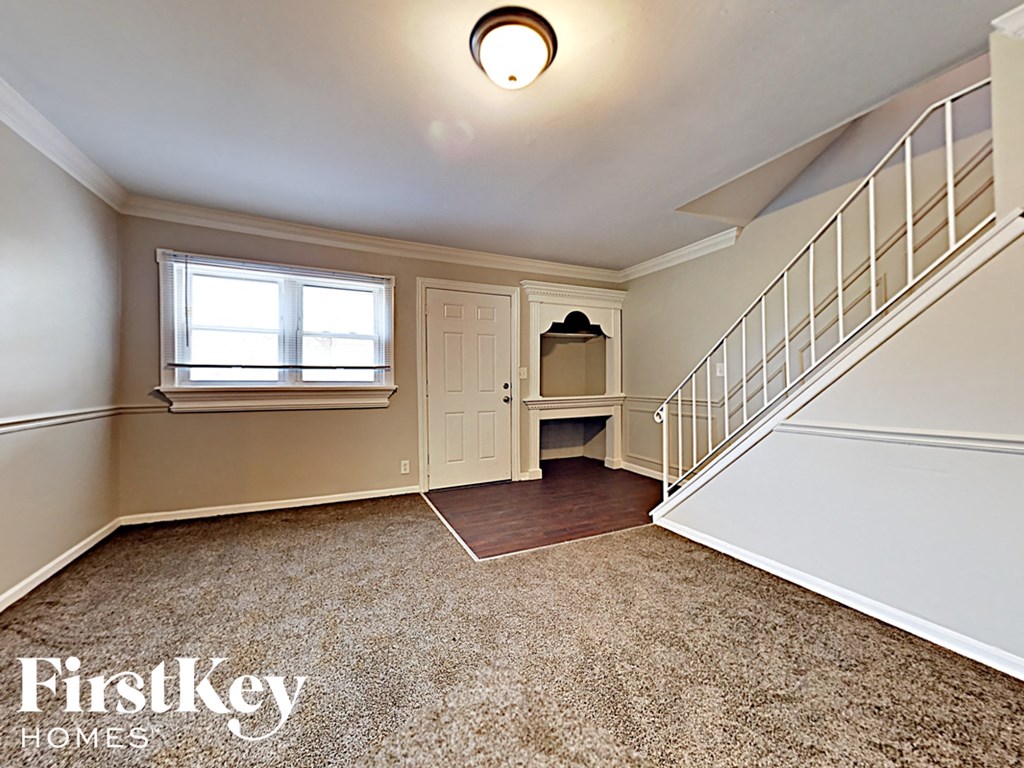 a fisheye lens view of an empty upstairs room with a white staircase