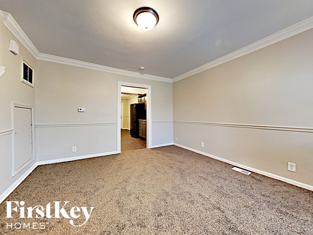 an empty living room with carpet and white walls