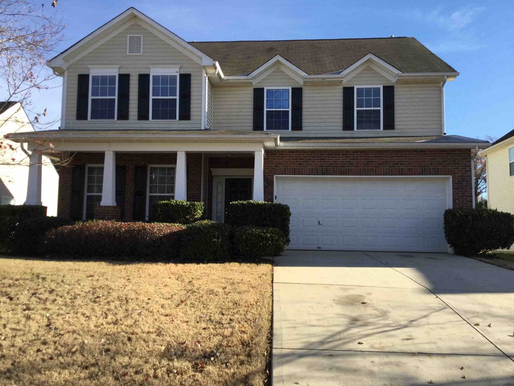 A two-story house with a garage and a driveway.