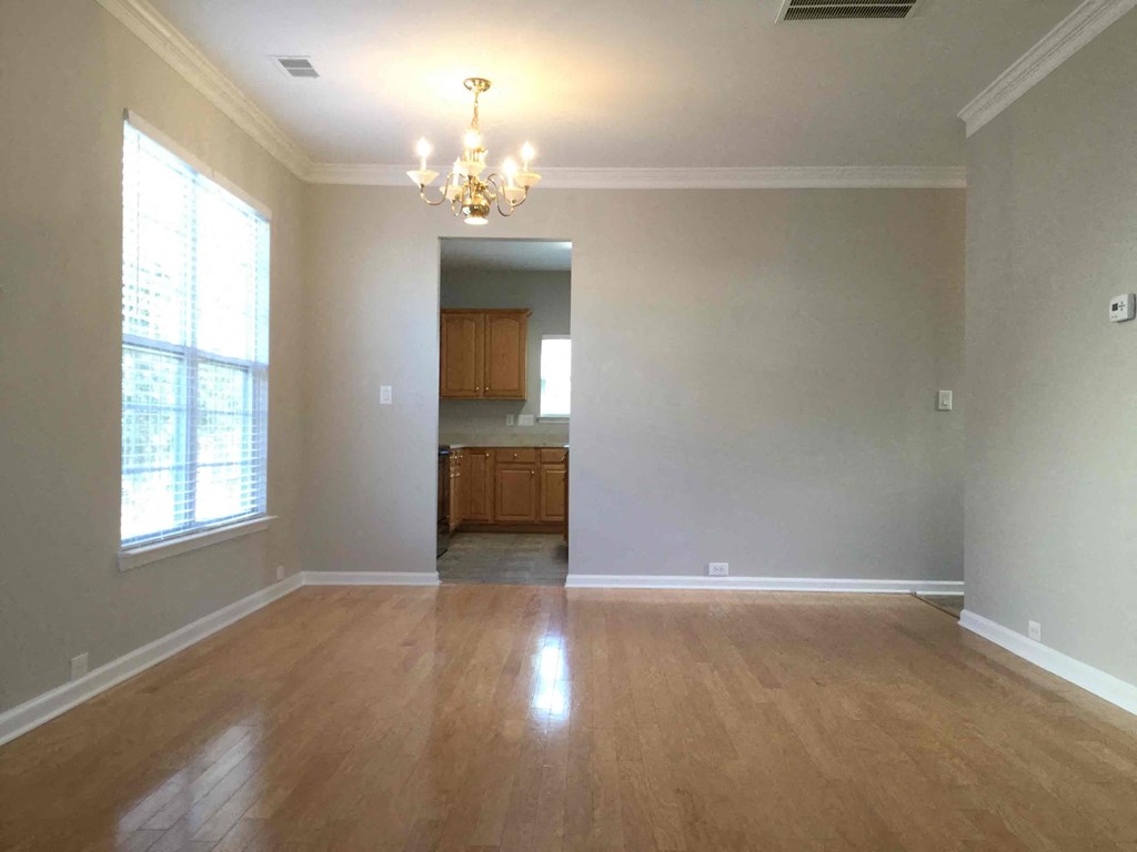 A room with wooden floors and a chandelier.