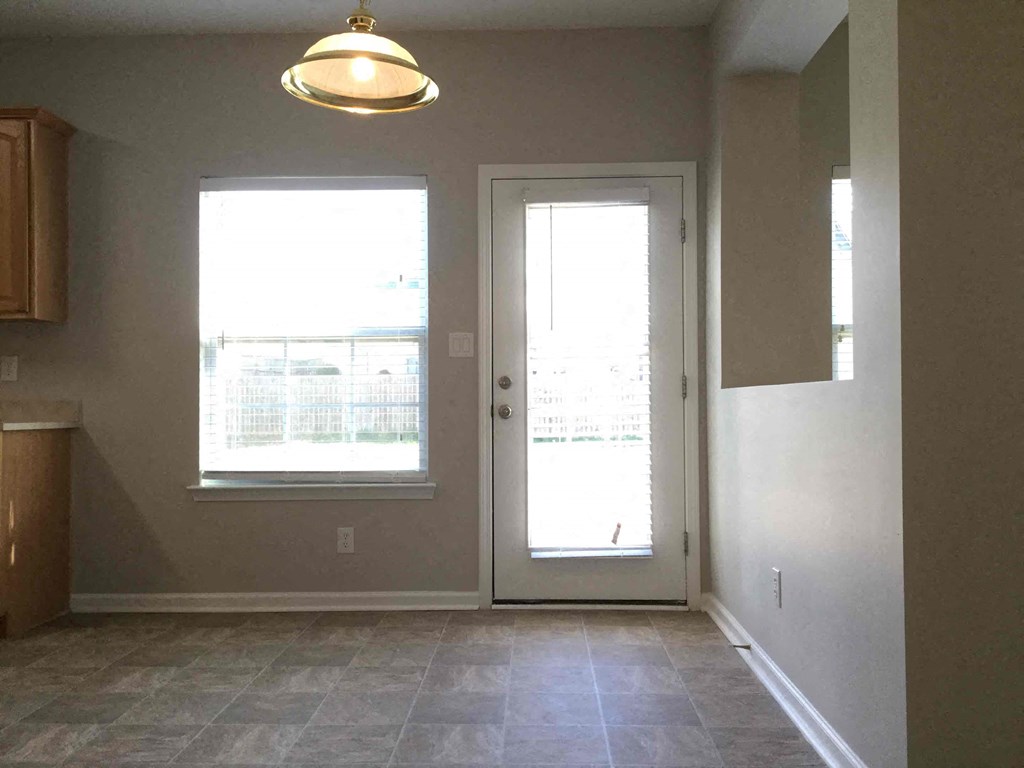 A room with a tiled floor and a door leading to a balcony.