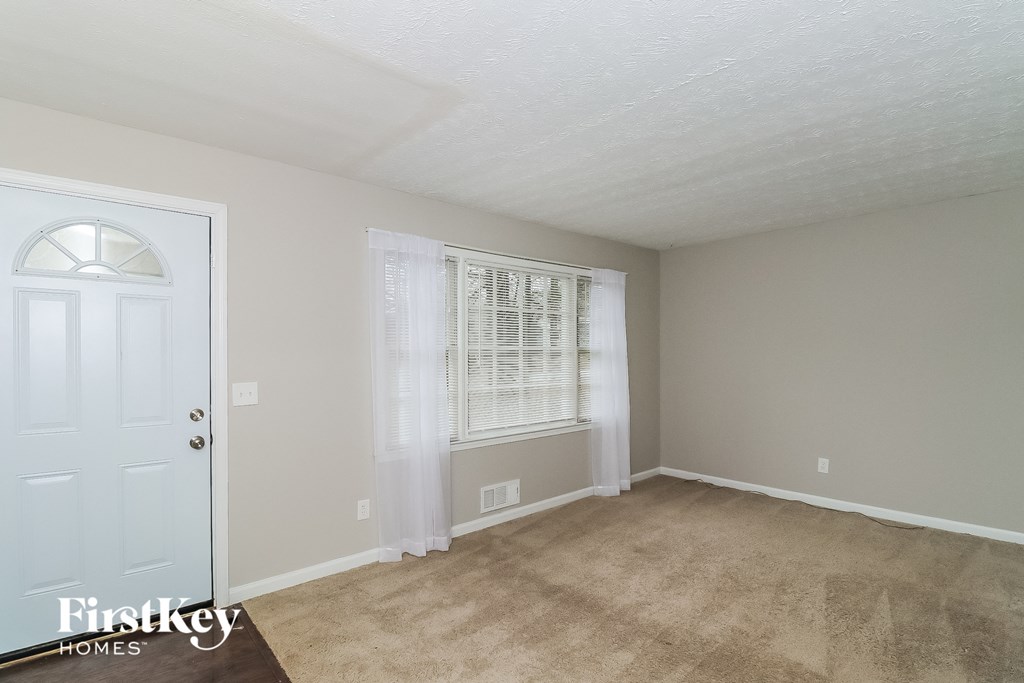 A room with a door and a window with curtains.
