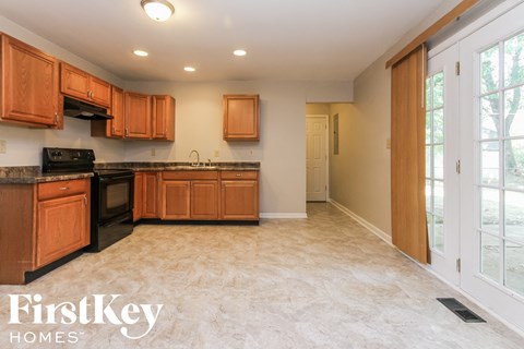 a kitchen with wooden cabinets and black appliances and a window