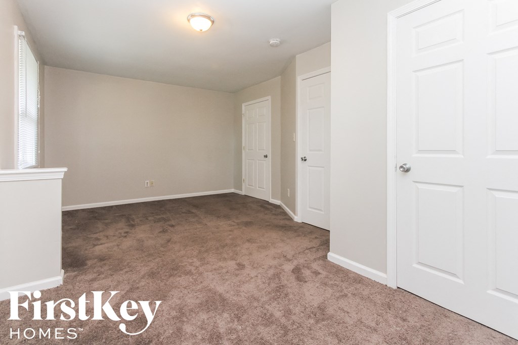 a bedroom with a carpeted floor and white doors