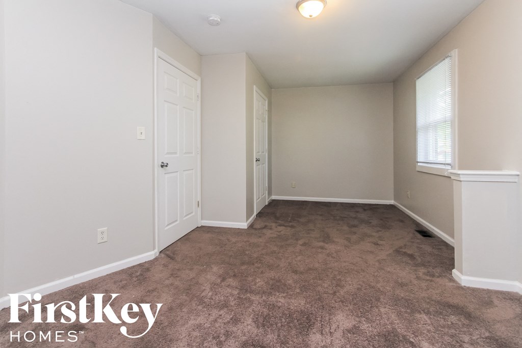 a bedroom with a carpeted floor and a white door